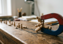 Magnet attracting small wooden figurines across a desk